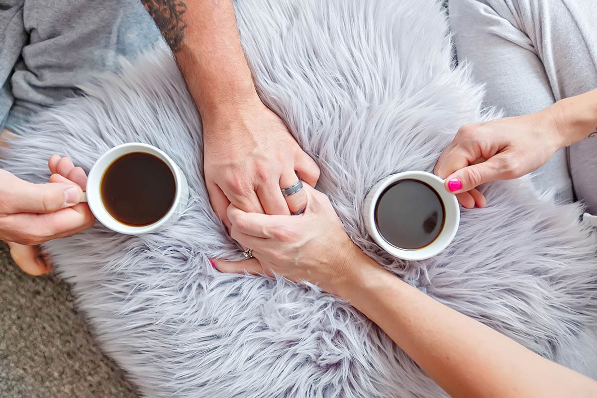 Couple holding hands with coffee cups