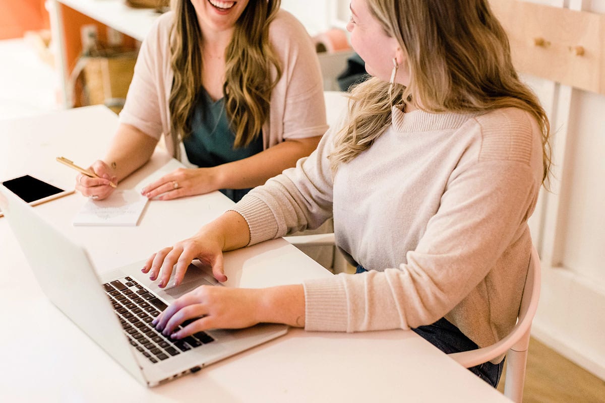 How to Get Rid of the Sunday Scaries | Two female coworkers laughing together