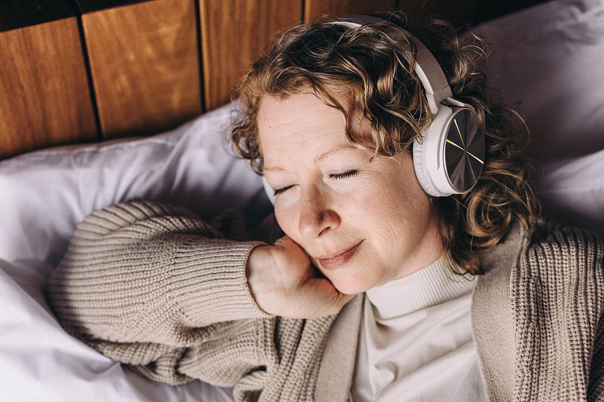 Middle-aged women relaxing and listening to music on headphones