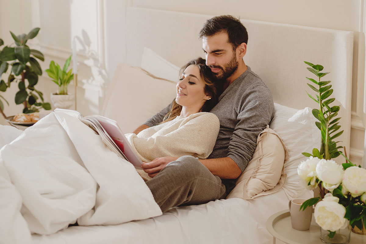 Relationship Rituals 2 - Couple snuggling in bed reading