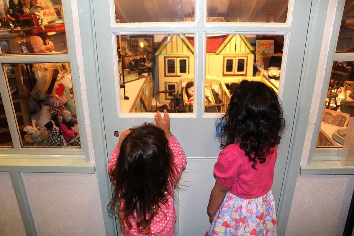 Being a Mom 4 | Two young girls looking at museum exhibit of toys