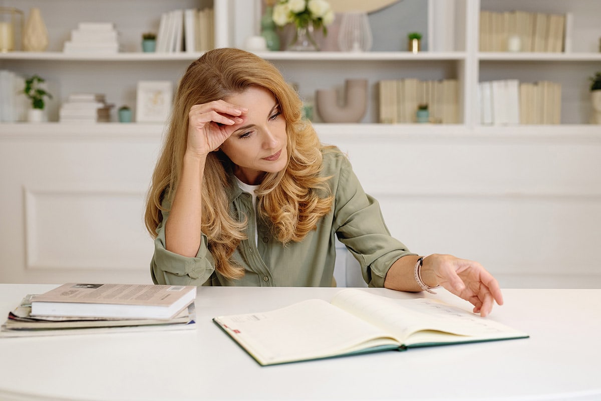 Woman reading book looking stressed out