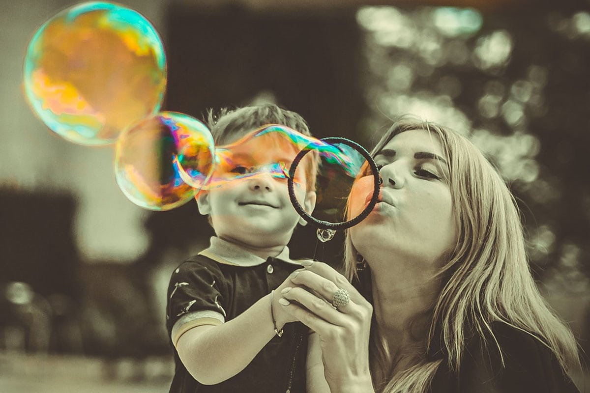 Mother and young son blowing bubbles