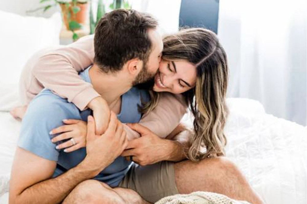 Couple snuggling and giggling on a bed