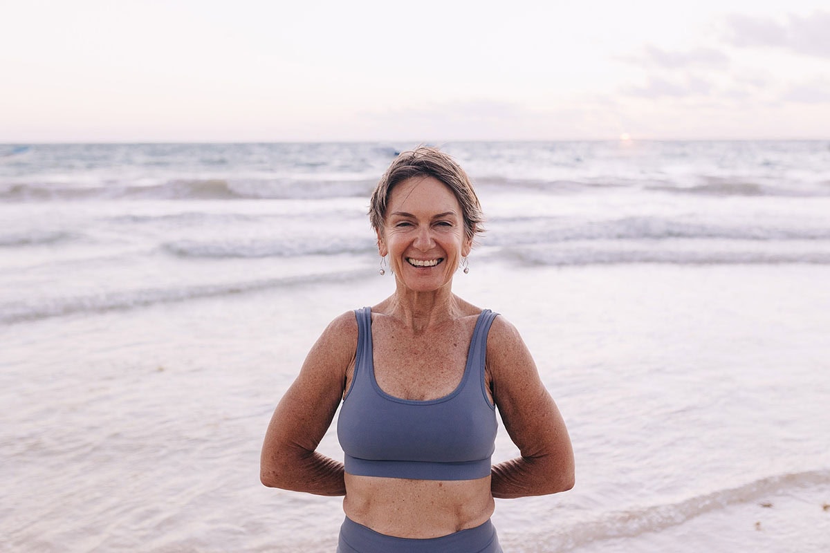 Middle aged woman smiling on the beach