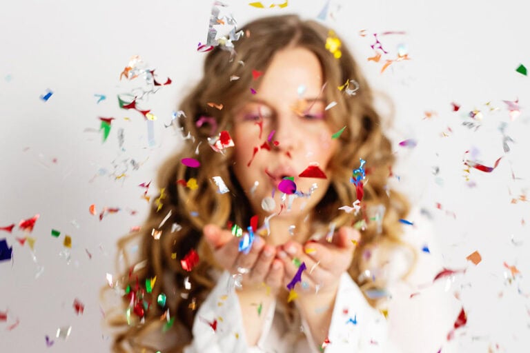 Celebrate Yourself 1 | Strawberry Blonde woman blowing confetti at the camera