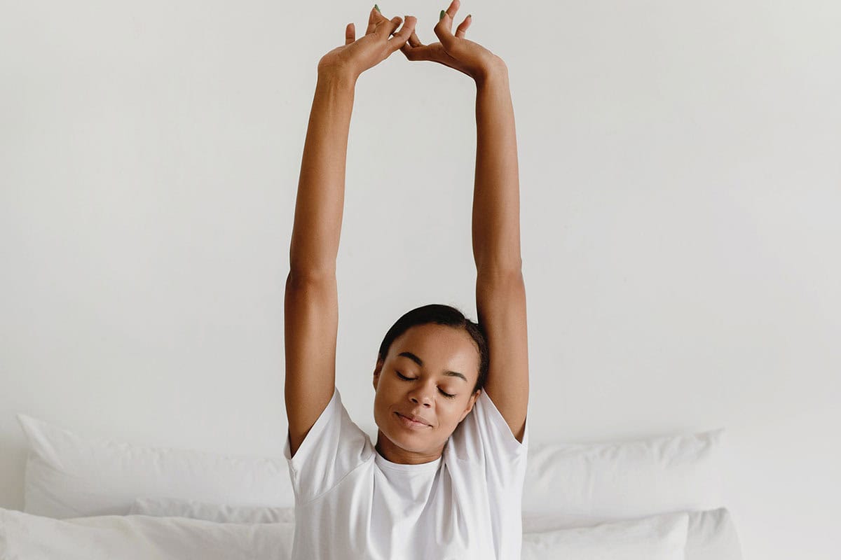 Woman stretching in bed