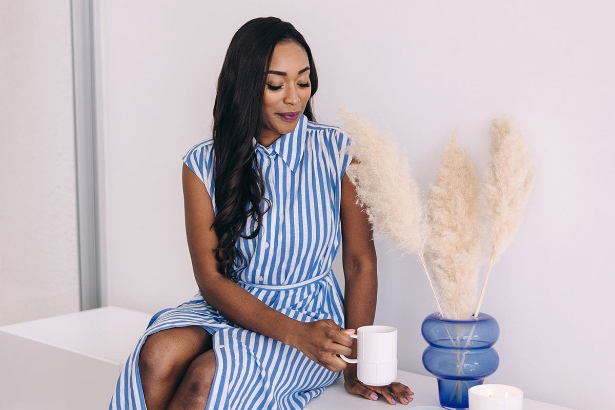 Woman in blue holding white mug