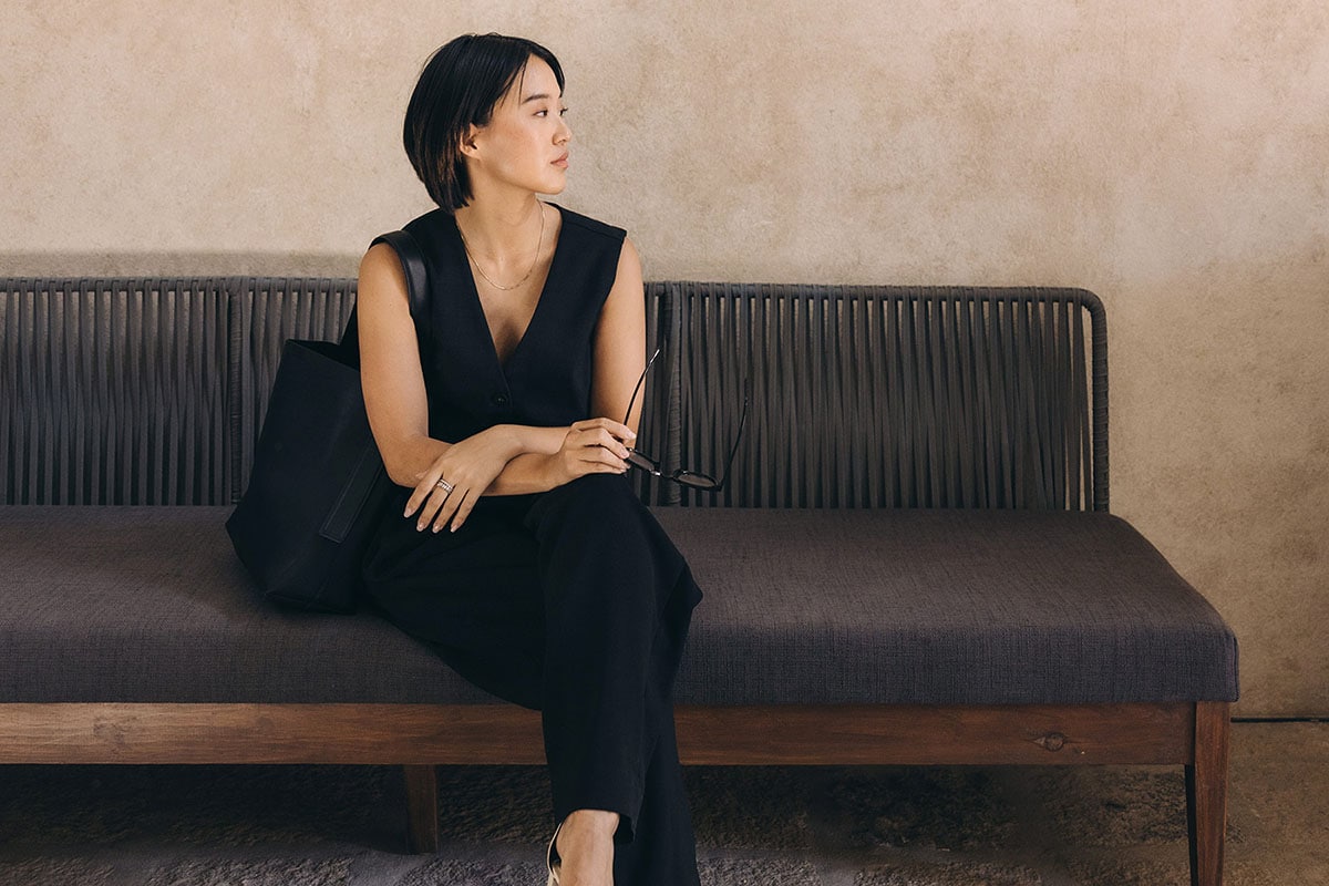 Woman in all black sitting on black bench