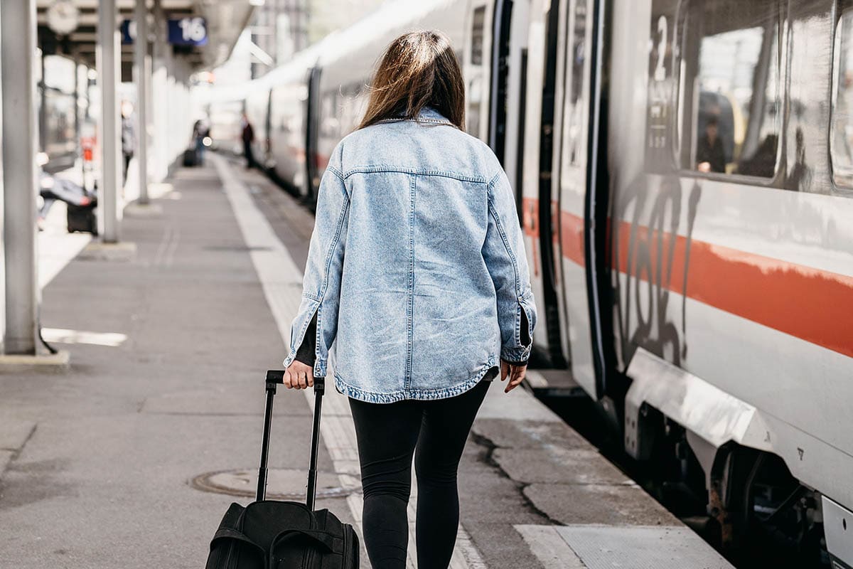 Woman on train platform with rolling bag