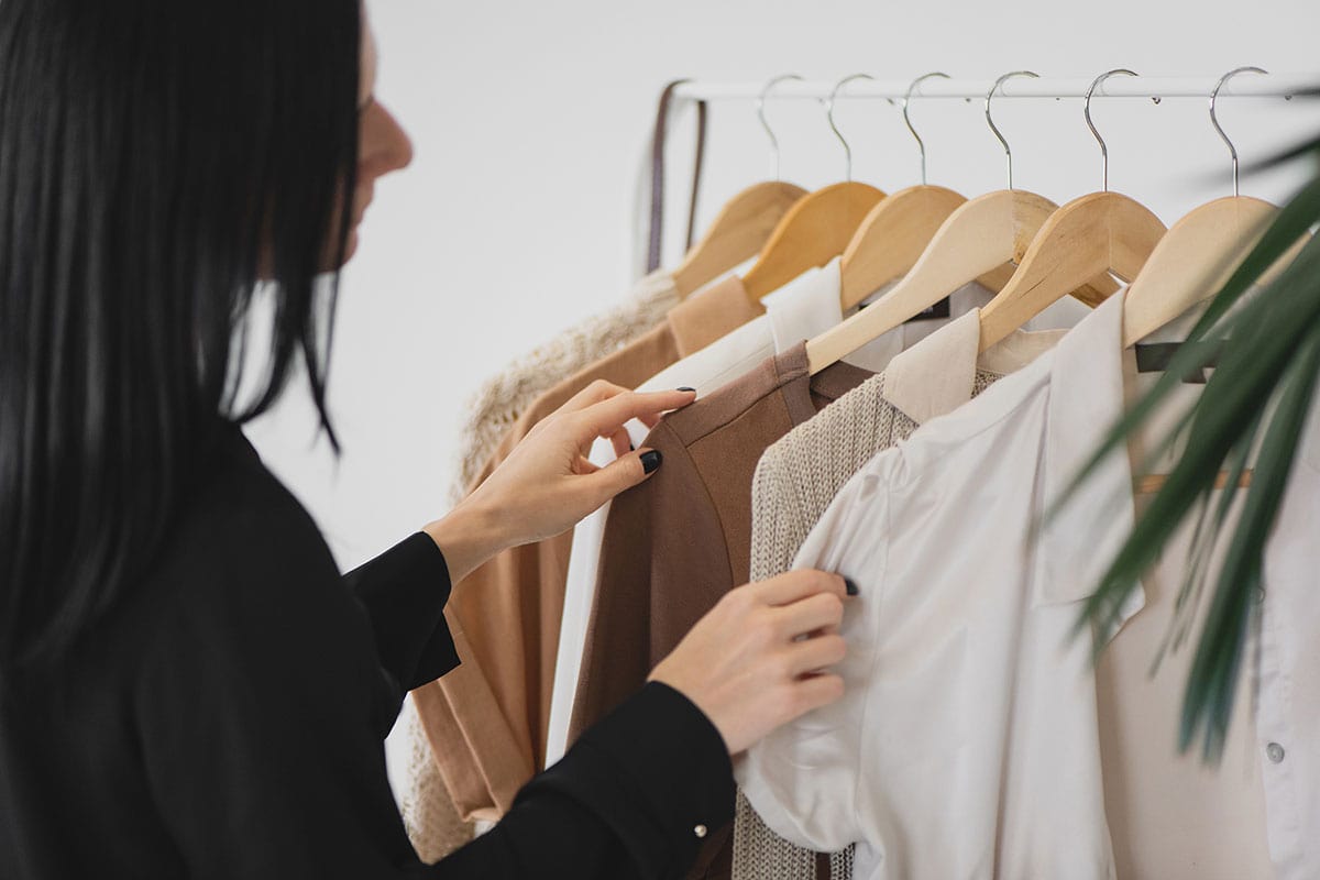 Woman sorting through clothing on a rack