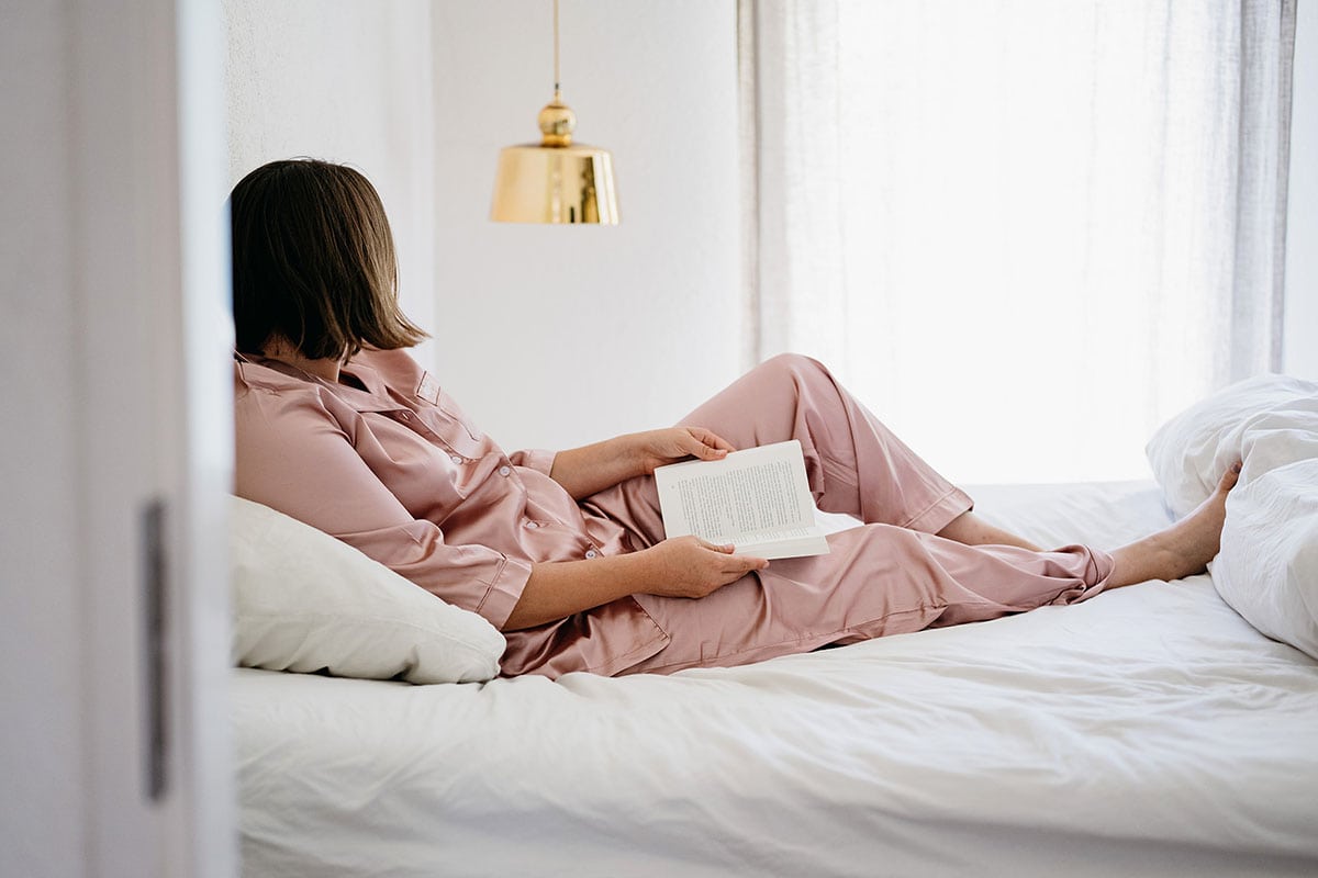 Lifestyle Creep 3 | Woman looking off in distance from bed