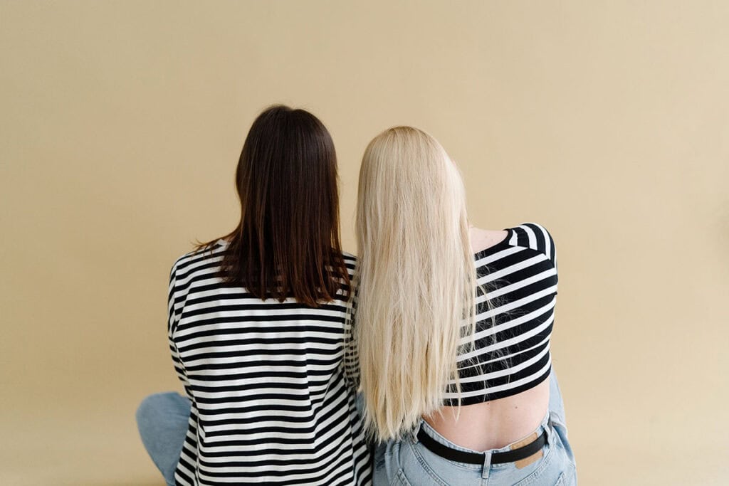 Adult Friendships are Hard | Two Women leaning on each other against neutral background